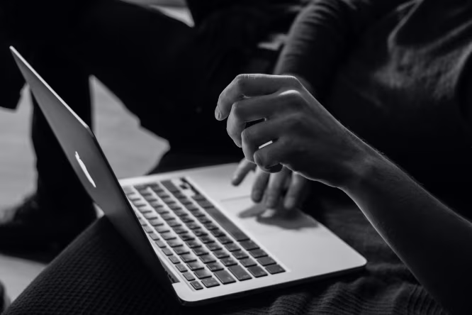 Close-up handen die typen op laptop toetsenbord relax wij regelen de technische zaken website beheer en beveiliging